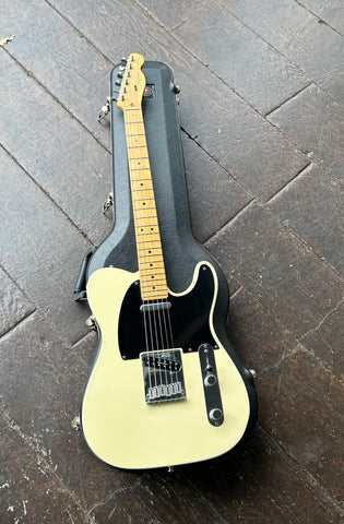 Top view off white telecaster with black pick guard, chrome hardware, maple fretboard, maple Fender headstock, six in line chrome tuners,