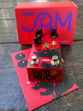 Red guitar pedal with 'Red Muck' branding on a wooden surface, with a red 'JAM' box in the background.