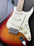 close up sunburst stratocaster with EMP pick ups with white pickguard, volume, and two tone knobs