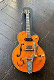 Gretch orange finish guitar with bigsby, two pick ups, gold control knobs, western motif inlays, brown Gretsch headstock