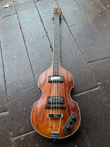 front koa violin shaped bass, two metal pick ups with metal pick up covers, rosewood neck, koa headstock