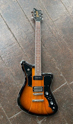 Brown sunburst Rivolta electric guitar, with black pick guard and two control knobs, chrome humbucker and black P90 pick up, rosewood fretboard with white dot inlays, black headstock with Rivolta gold script