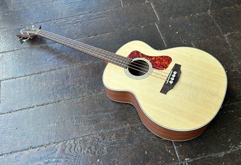 Spruce top acoustic bass body with red pickguard, roswood fretboard with dot inlay and dark wood Guild headstock