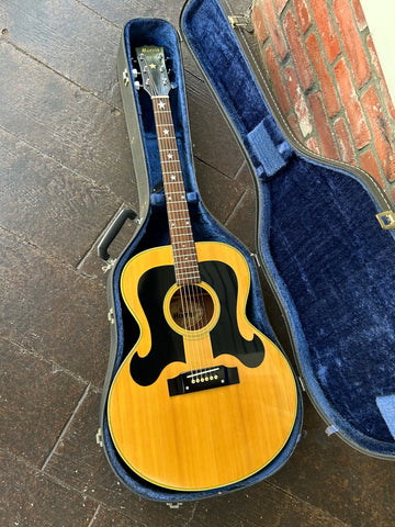 Jumbo spruce top acoustic with black swirl pick guard around soundhole, rosewood fretboard with perl star logos and black headstock with star logo