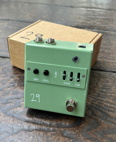 front view green guitar pedal nwith gain, level knobs and shape and clip sliders, single chrome button control