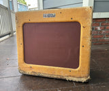 Vintage Fender amplifier on a wooden deck with a house in the background