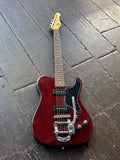 Red electric G&L guitar on a wooden floor
