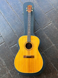Goya Tenor acoustic guitar with rosewood bridge natural top, rosewood fingerboard and rosewood headstock on case displayed on wooden floor