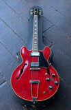 A 1968 Gibson ES-335 electric guitar with a black pickguard and rosewood neck, resting inside a black hard case on a dark wooden floor.