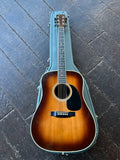 A 1978 Martin D-35 acoustic guitar in a sunburst finish, resting inside its teal hard case on a dark wooden plank floor.