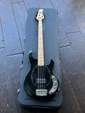 2006 Ernie Ball Music Man StingRay 4 (3 EQ H) with Maple Fretboard black finish, maple fretboard and headstock, on black case, resting on wood flooring

