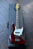 2010 Fender Custom Shop Custom Classic Jazz Bass V Special, Bing Cherry Transparent finish, with chrome hardware, two pickups, rosewood fretboard, maple headstock resting on it's black case displayed on wooden floor 