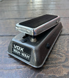 Silver an black VOX Wah-Wah pedal on a wooden surface