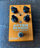 Guitar effects pedal with 'After Shock Bass Distortion' orange with four control knobs 