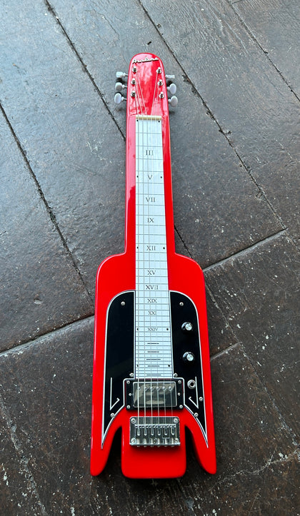 Red electric lap steel guitar  ona dark concrete floor