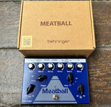  blue Behringer Meatball effects pedal with its packaging on a wooden surface
