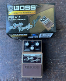 A brown Boss Frv-1 Fender Reverb guitar effects pedal shown in front of its original retail box, placed on a dark textured surface. The pedal is brown with silver knobs and a black control panel, and the box features the Boss Legend Series branding.