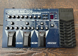 A BOSS ME-50B Bass Multiple Effects pedal unit in blue with black footswitches and knobs, photographed from above on a brown wood surface.