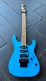 Charvel Blue electric guitar on a dark tiled floor