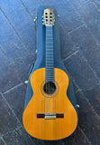 Cordoba classical guitar with cedar top and ebony fret board, rosewood bridge and headstock on black case on wood floor