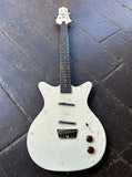 White electric guitar with starburst pattern on a dark wooden floor Danelectro Golden '50s Electric Guitar - Cream