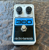 Electro-Harmonix Nano Looper 360 guitar effects pedal with white casing, black knobs, blue accents, and a silver footswitch, photographed on a textured dark surface.