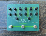 An Electro-Harmonix Tri Parallel Mixer guitar effects pedal with a teal green faceplate, black rotary knobs, and silver footswitches, photographed from directly above on a dark wood surface.