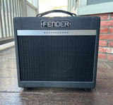Fender Bassbreaker grey small guitar amplifier on a wooden surface with a brick wall in the background