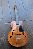 mahogany Vintage acoustic guitar on a textured dark surface
