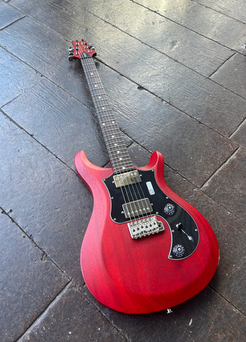 Red cherry mahogany, with chrome humbuckers, chrome tremolo, black pick guard, with rosewood fretboard, white perl fret markers, red cherry headstock and 
