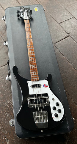 Black Rickenbacker bass, two black pick ups, four  black knobs, white pickguard with roswood fretboard and white dot inlays, with black headstock, and Rickenbacker white truss rod cover