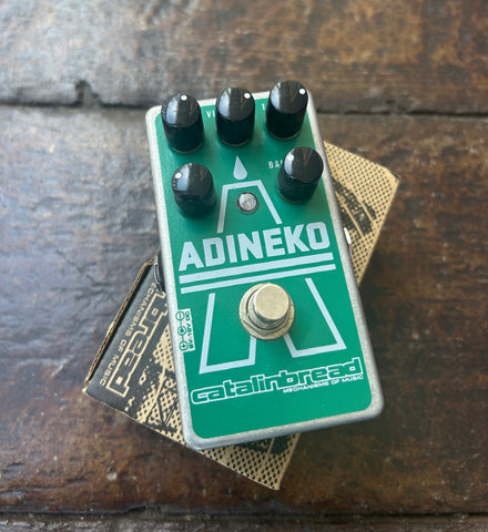 Green Adineko pedal with white lettering, five black control knobs