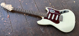 Side view , top rosewood fretboard, squier headstock with metal tuners, white body with metal tremolo, white pick ups, with tortoise pick guard cover 