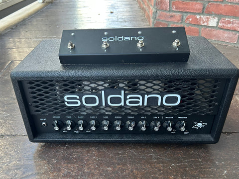 Soldano Astro 20 black guitar head with metal frill and eleven knob controls, with black footwitch on top of amplifier