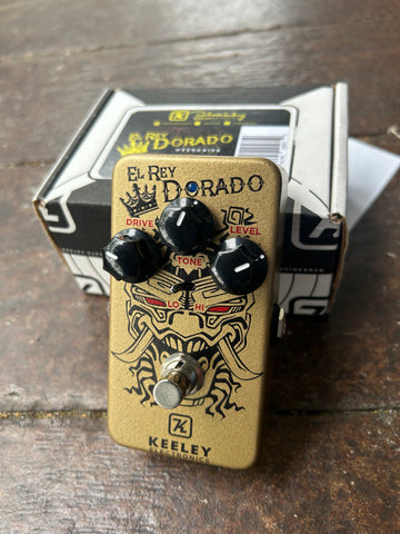 Gold guitar pedal with black design and black knobs