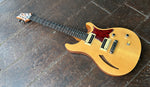 Maple gloss top PRS SE with black and tan pick ups, wrap around bridge, red pickguard, rosewood fretboard with abalone dot inlays, wood headstock