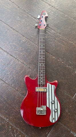 top view: Red Mini Teisco bass, metal striped pick guard, gold foil pick-up. rosewood fretboard, dot inlays, red headstock, teisco badge  