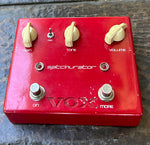 Red guitar effects pedal with 'VOX' branding on a textured surface