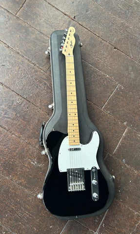 front view Fender black telecaster with white pickguard, two pick ups, metal bridge, maple neck with Fender maple headstock