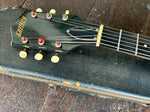 close up hblack headstock with Gretsch Gold lettering, black truss cover, six off white tuners buttons