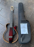 Yamaha SLG200NW Silent Nylon-String Wide-Neck guitar with wood frame, ebony fretboard and brown headstock.
Displayed with black gig bag and manual  