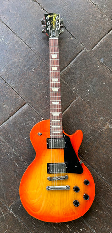 Top view tangerine burst Les Paul with chrome hardware and two chrome pick ups, rosewood fretboard with trapezoid inlays, black headstock with Gibson logo and grover tuners