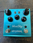 Blue metal Strymon Blue Sky pedal, five black control knobs, two metal button foot controls