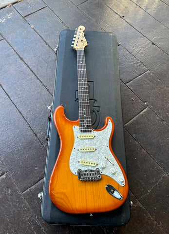 Front view G&L electric guitar orange honey burst, pearloid pickguard , with rosewood fretboard, white inlay dots, maple headstock, with six in line tuners