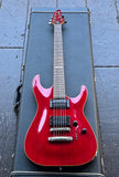 A red ESP electric guitar with rosewood fretboard, a glossy finish resting inside an open black guitar case on a gray paved surface.
