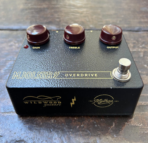 Mythos x Wildwood Guitar Mjolnir Overdrive black guitar effects pedal with three control knobs, single button footswitch 