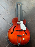 top view red harmony rockey, single pick up, two knobs, with rosewood fretboard, dot white dot inlays and brown headstock with Harmony script and rocket script
