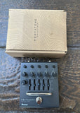 black Pentatone Equalizer guitar pedal on a wooden surface with its packaging above it.