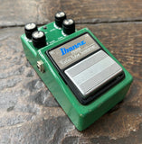 Green Ibanez tube screamer guitar effects pedal on a wooden surface
