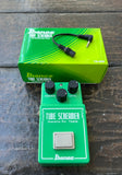 Green Ibanez Tube Screamer pedal with green box on a wooden surface